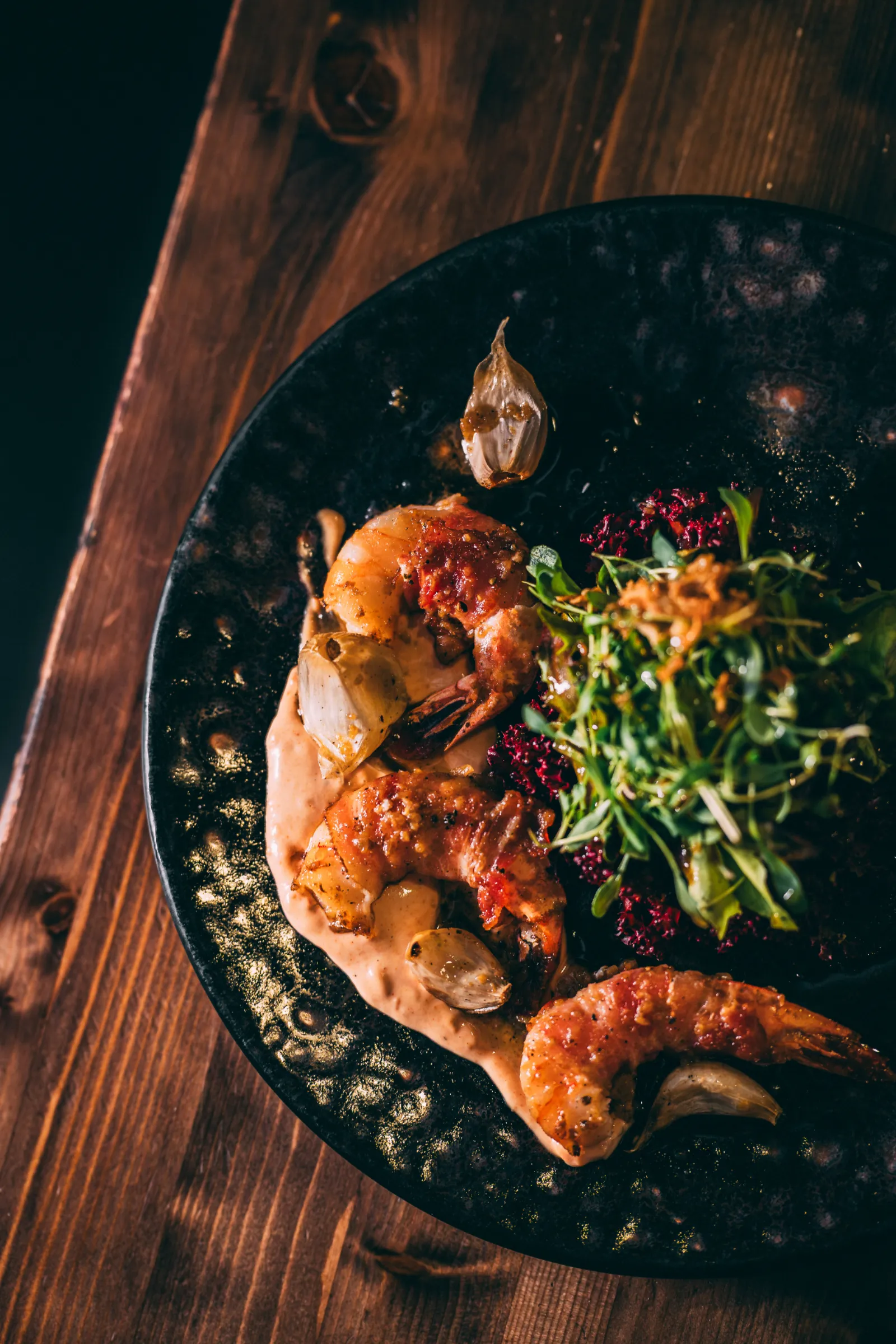 Food Fotografie – Bacon-Garnelen mit Wildkräutersalat auf rustikalem Holztisch
